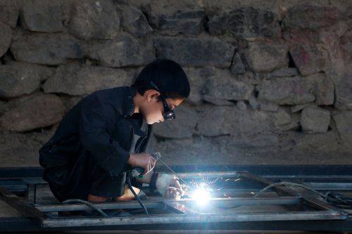En afghansk dreng svejser en ramme på et værksted i Fayzabad-distriktet i Badakhshan.