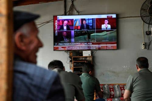 Mænd ser med på nyhederne på en tv-skærm i et tehus i Diyarbakir den 12. maj 2025, hvor det annonceres, at PKK (Kurdistans Arbejderparti) opløses. PKK meddelte denne dag, at det opløses, og at det indstiller sine kampe mod Tyrkiet.