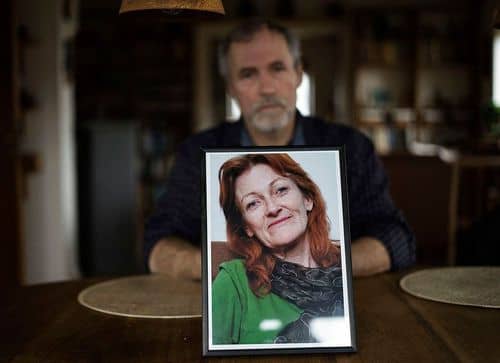 Mand der sidder med et billede af en kvinde