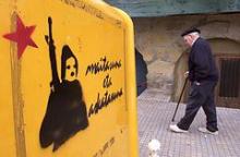 En ældre basker passerer ETA graffiti i landsbyen Pasaia op til valget i 2000.