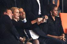 Barack Obama og David Cameron poserer foran et selfie billede taget af Helle Thorning Schmidt ved begravelses ceremonien for Nelson Madela den 10. december 2013.