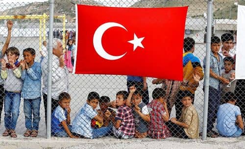 børn bag hegn med tyrkisk flag